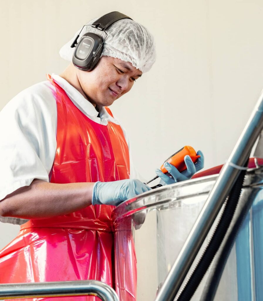 Springbrook Foods production team member checking sauce manufacturing process in stainless steel tank at world-class facility.