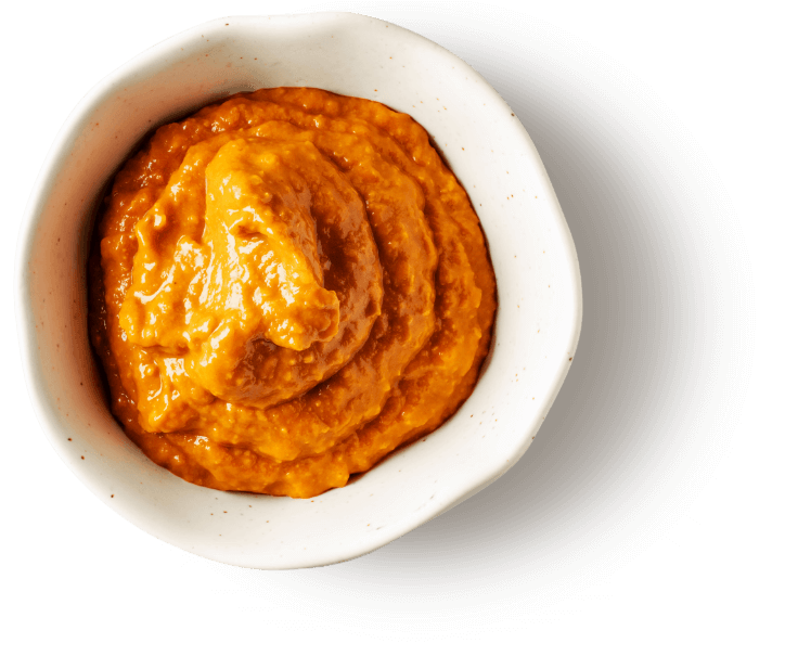 Bowl of rich orange sauce representing bespoke product development.