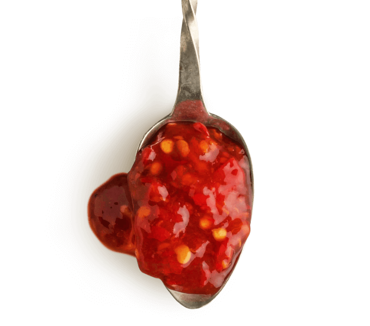 Spoonful of chunky chilli relish illustrating ingredient blend development.