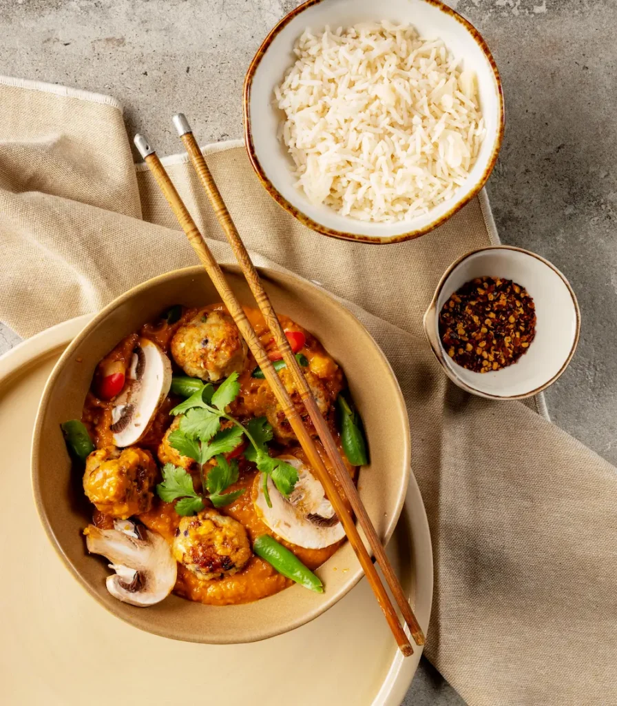 Prepared meal with meatballs in the Springbrook no-nut satay sauce served with rice, showcasing finished food application