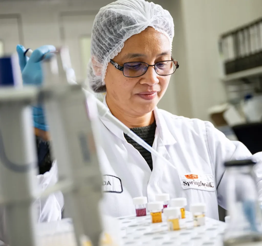 Food technologist in lab testing sauce samples with pipette